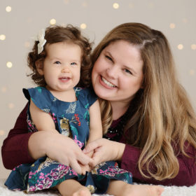 Mom and daughter smiling in studio with twinkle bokeh lights background