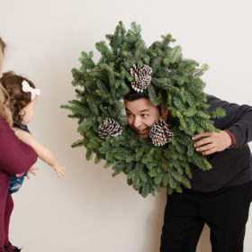 Dad making funny faces with holiday wreath in studio