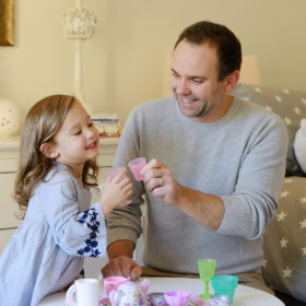 Dad and daughter having a tea party in her room