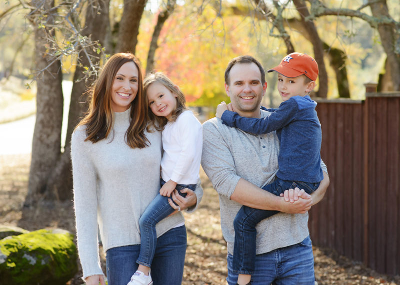 Family photo outdoors with tree foliage