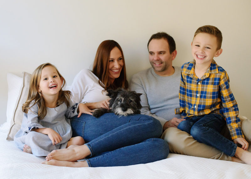 Lifestyle family portrait in bed with dog 