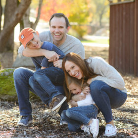 Family laughing outdoors with Sacramento background foliage