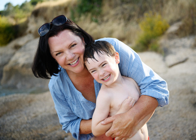 Mom hugging son on beach at Folsom Lake State Recreation Area