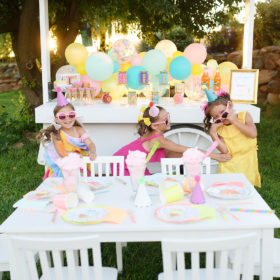 Girls wearing sunglasses and giggling in front of sweet themed birthday