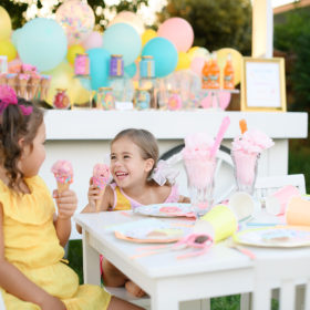 Little girl with icecream on her nose laughing at party table
