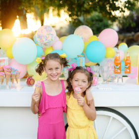 Little girls eating icecream in front of dessert display birthday party