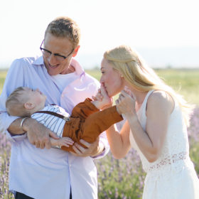 Mom kissing one year old son’s foot as dad holds him in lavender fields in Dixon