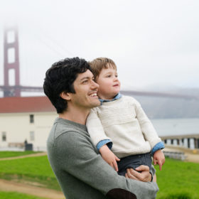 Dad and son looking out in the distance with Golden Gate Bridge as the backdrop in Crissy Field