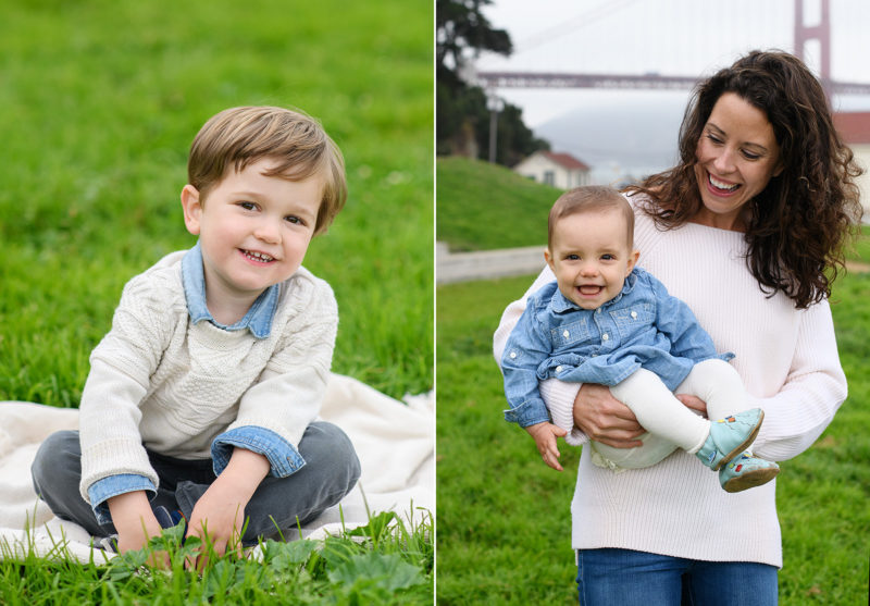 Toddler boy sitting on blanket on grass and mom holding baby girl in front of Golden Gate Bridge in Crissy Field