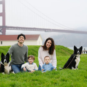 Family with their dogs posing in front of Golden Gate Bridge in Crissy Field