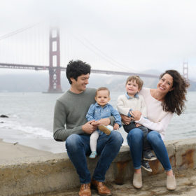Family posing in front of foggy Golden Gate Bridge in San Francisco