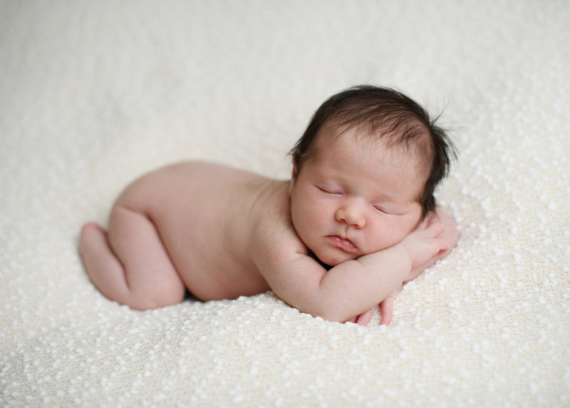 Sleeping newborn baby on white blanket in Sacramento studio