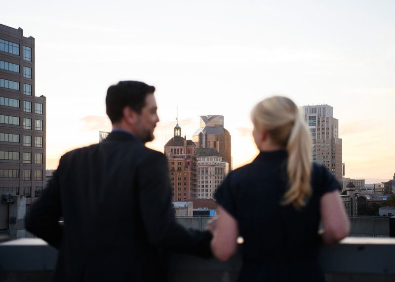 Couple on a Downtown Sacramento rooftop admiring the skyline 