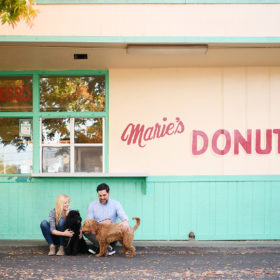 Couple with two dogs sitting in front of Marie’s Donuts in Sacramento engagement photo