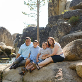 Family portrait on smooth rocks by Lake Tahoe shore
