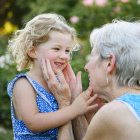 Grandma caressing granddaughter’s face in McKinley Park Rose Garden in Sacramento