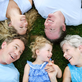 Family photo lying on the grass and smiling in McKinley Park Sacramento