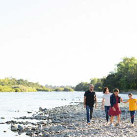 Family walking along river on smooth rocks in Fair Oaks
