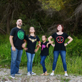 Family wearing superhero shirts striking a pose outside in Fair Oaks