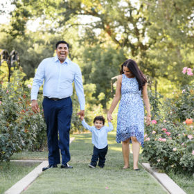 Mom and dad holding on to one year old boy’s hands as they walk through McKinley Park Rose Garden Sacramento