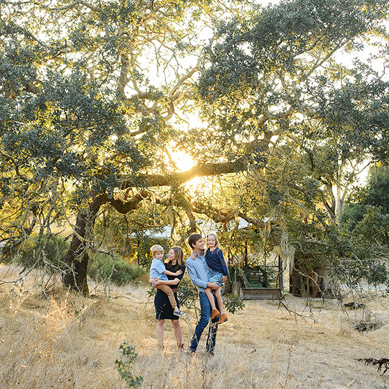 Family photo during sunset among big trees in Quarryhill Botanical Garden in Glen Ellen Sonoma