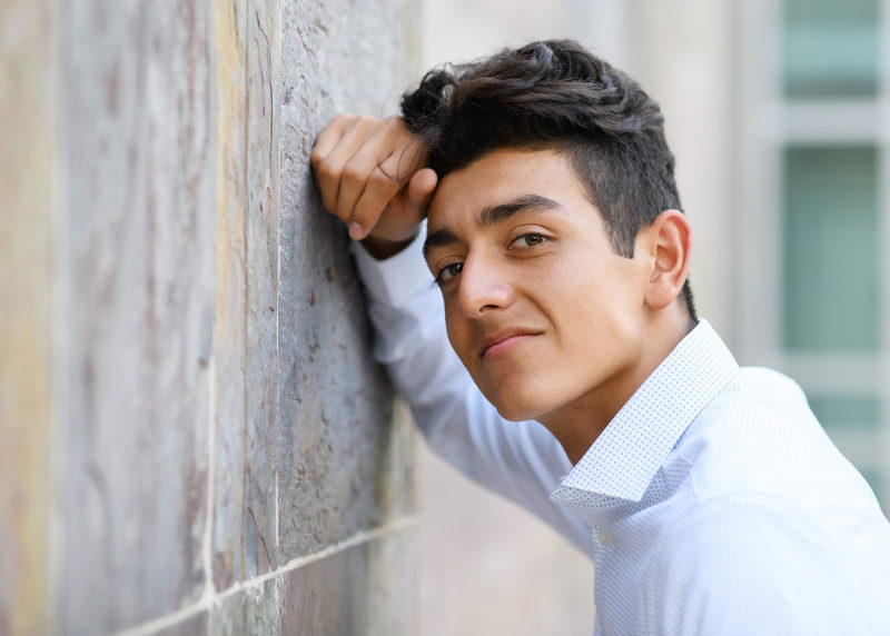 Close up of senior boy leaning against wall in El Dorado Hills