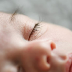 Close up of newborn baby sleeping with long lashes in studio