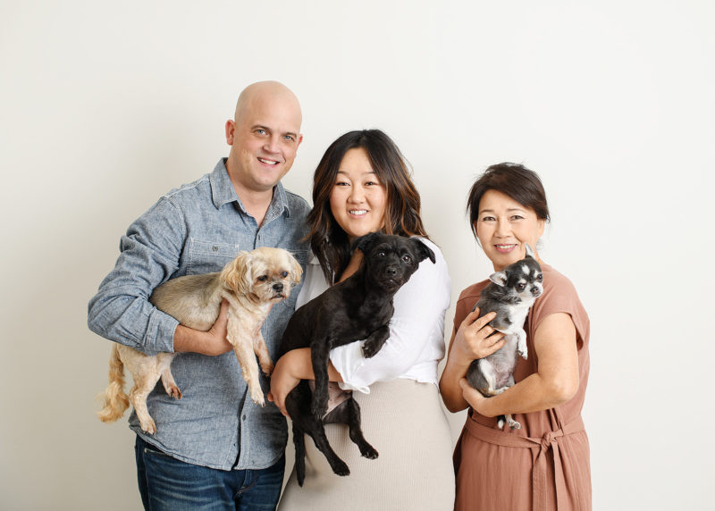 Husband, pregnant wife and mom all holding dogs and smiling in Sacramento studio