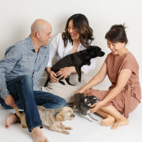 Husband, pregnant wife and mom all playing with their dogs while sitting in Sacramento studio