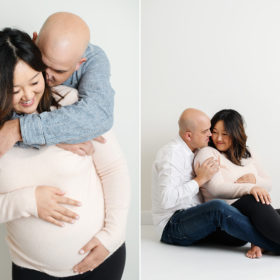 New parents hugging each other lovingly as mom caresses baby bump maternity photo in studio