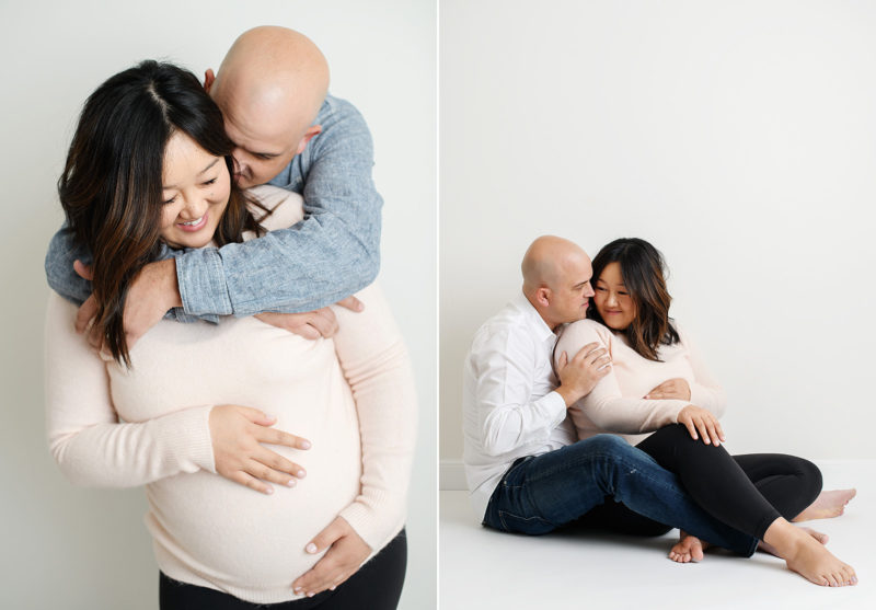 New parents hugging each other lovingly as mom caresses baby bump maternity photo in studio