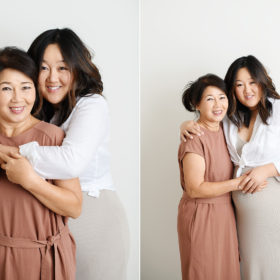Asian mother and pregnant daughter embracing in Sacramento studio