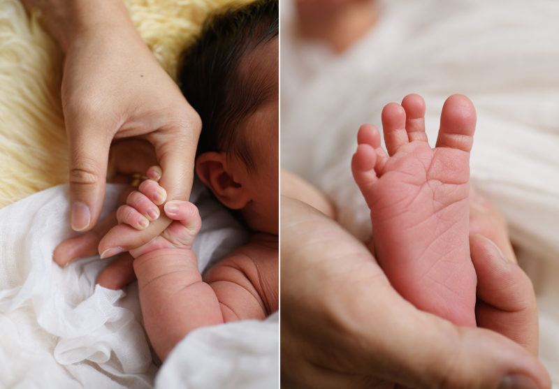 Newborn baby girl holding on to mom's finger. Close up of baby toes.