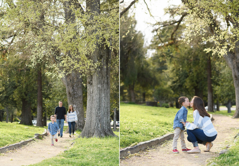 Little boy walking in front of parents outdoors near tall oak trees in Sacramento