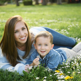 Mom and son lying in grass and wildflowers in Sacramento park