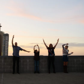 Family silhouette spelling out LOVE on Sacramento rooftop against sunset