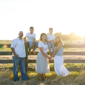 Family photo by the fence during sunset in Sacramento