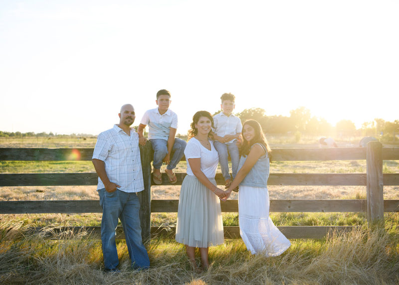 Family photo by the fence during sunset in Sacramento