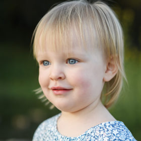 Blonde toddler girl with blue eyes close up outdoors in Fair Oaks