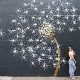 Teen girl posing in front of dandelion mural in downtown Sacramento