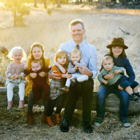 Grandpa sitting on a log with all the grandchildren in Folsom