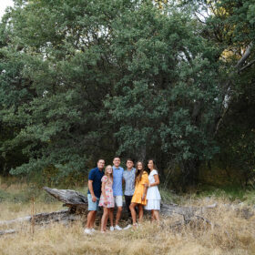 Group family picture in front of fallen log and dry grass with tall trees in background Folsom Lake