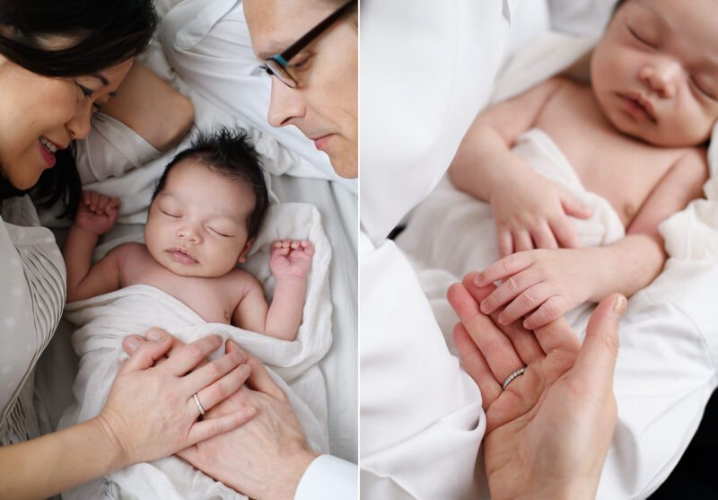 Mom and dad look lovingly at sleeping newborn baby boy while lying in bed in Sacramento studio