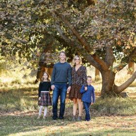 Fall family photo underneath large tree in Sacramento park