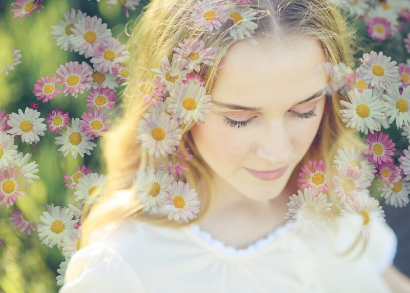 Double exposure image of teen girl with wildflowers in hair