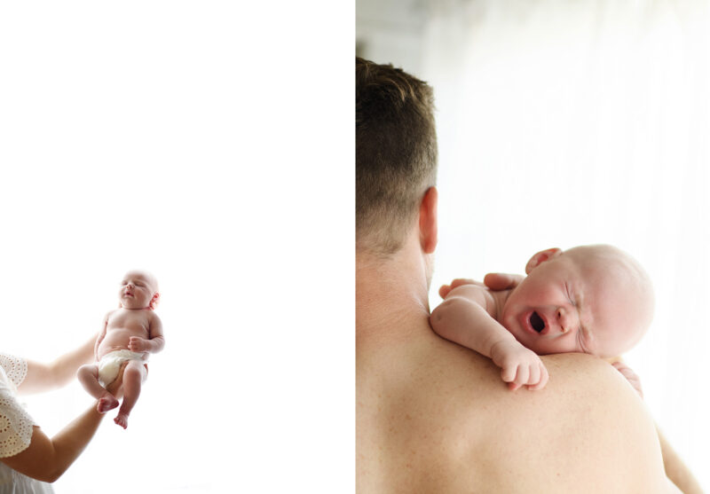 Newborn baby boy being held against white light background