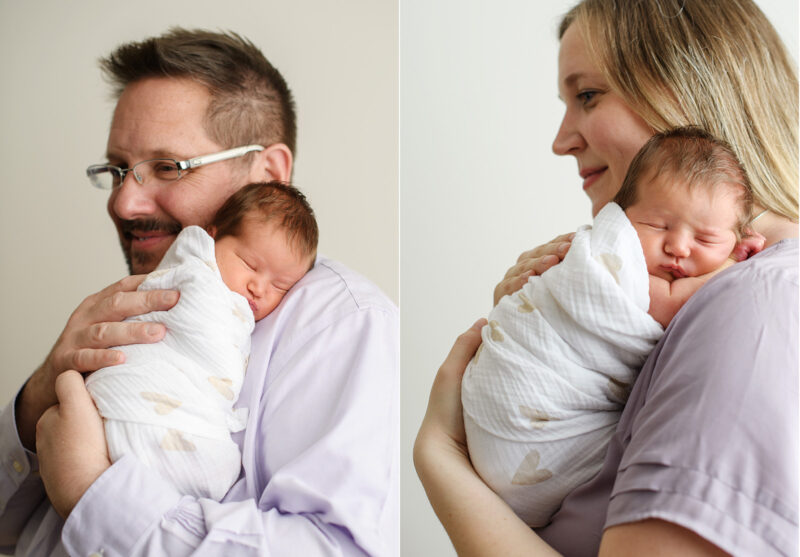 Mom and dad holding sleeping newborn baby in heart swaddle in Sacramento studio