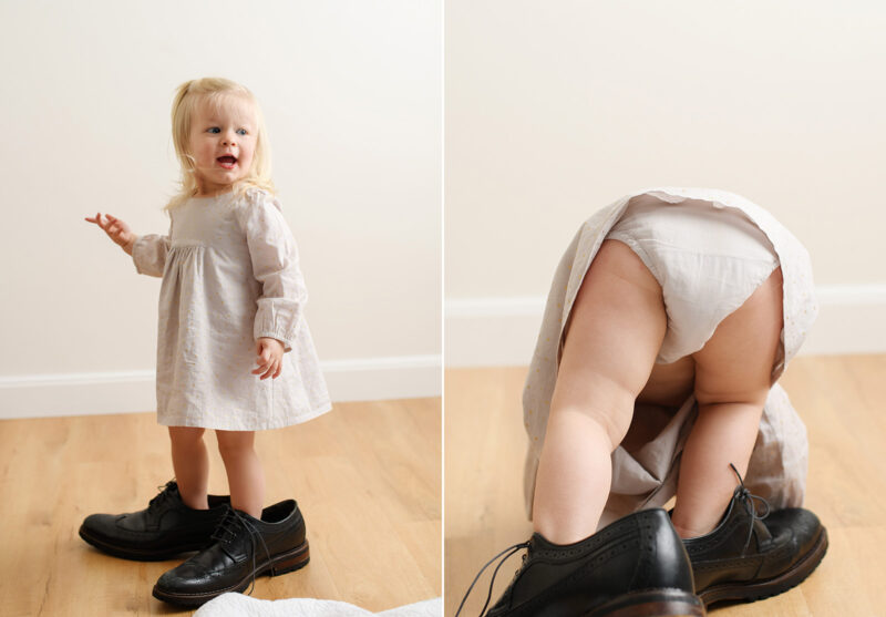 Toddler girl wearing dad's black shoes in Sacramento studio