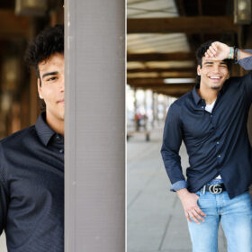 High school senior boy leaning against Sacramento waterfront pier and smiling