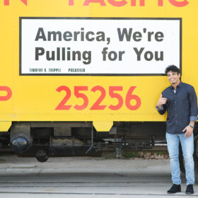 Teenage boy pointing at yellow train that says America, we’re pulling for you in Old Sacramento